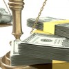An old school bronze justice scale with stacks of us dollar money on one side and a few crumpled notes on the other representing the inequality in the income gap an isolated white background